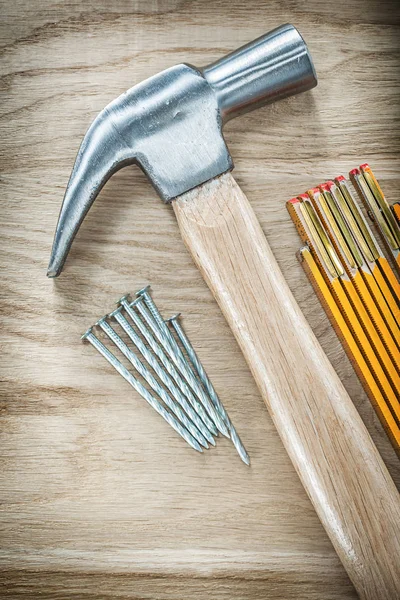 Klo hammare trä mätaren rostfria spikar på träskiva byggnad — Stockfoto