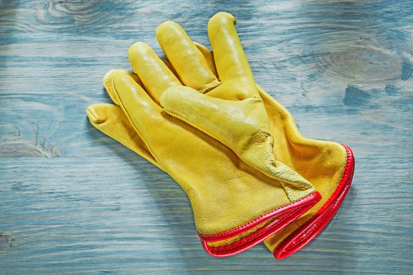 Leather working gloves on wooden board top view construction con — Stock Photo, Image