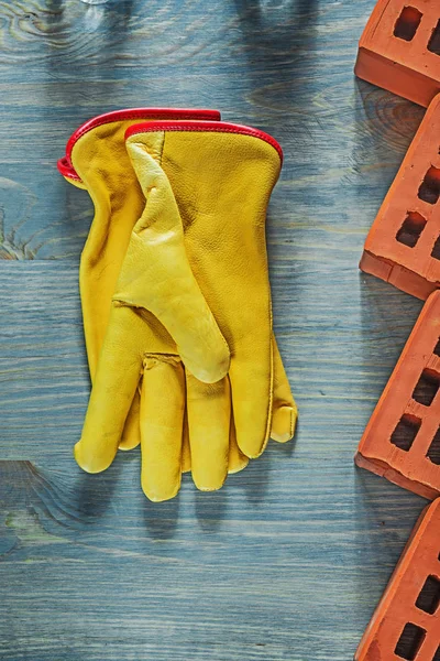 Läder säkerhet handskar röda tegelstenar på träskiva construction co — Stockfoto