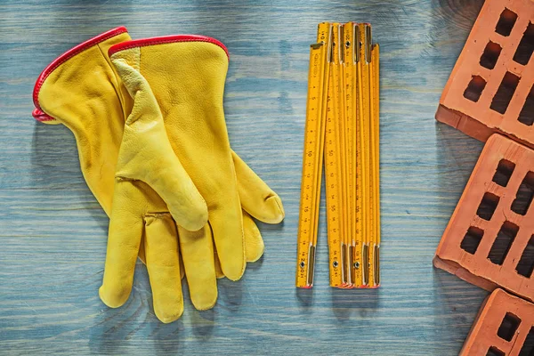 Kožené bezpečnostní rukavice červené cihly dřevěný metr na dřevěné desce bric — Stock fotografie