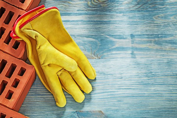 Ladrillos rojos guantes de seguridad de cuero en tablero de madera imag horizontal — Foto de Stock