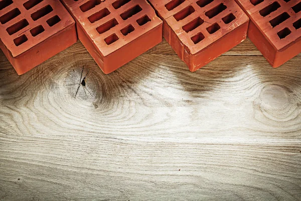 Red bricks on wooden board top view bricklaying concept — Stock Photo, Image