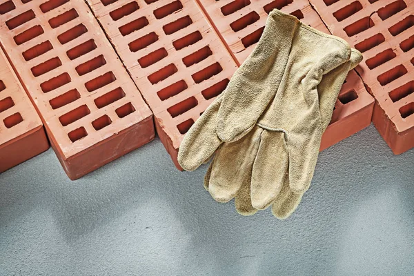 Ladrillos naranja guantes de trabajo de cuero en la superficie de hormigón constru — Foto de Stock