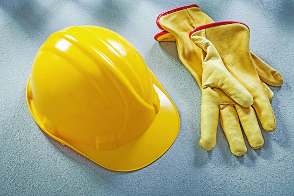 Hard hat leather safety gloves on concrete surface construction 