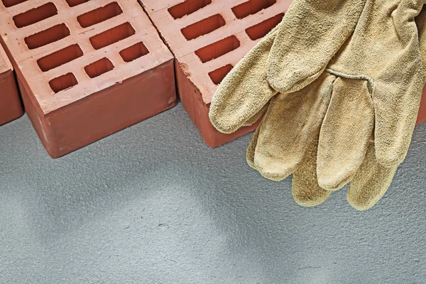 Naranja ladrillos guantes de trabajo de cuero en la superficie de hormigón buildin — Foto de Stock