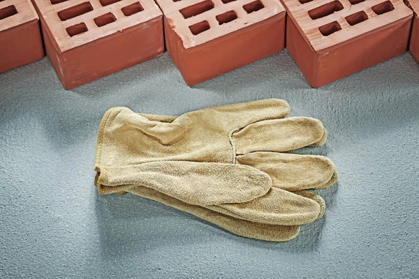 Orangefarbene Ziegel Lederschutzhandschuhe auf Betonoberfläche — Stockfoto