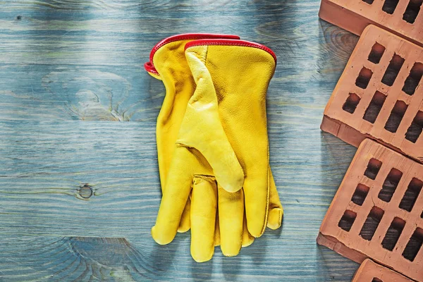 Guantes protectores ladrillos rojos sobre tabla de madera construcción cóncava — Foto de Stock