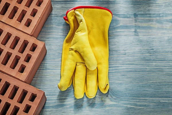 Guantes protectores ladrillos rojos en tablero de madera vista superior edificio c — Foto de Stock