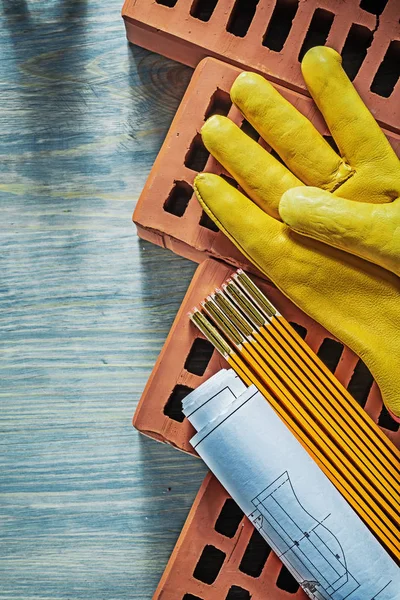 Blueprints luvas protetoras tijolos vermelhos medidor de madeira em madeira boa — Fotografia de Stock