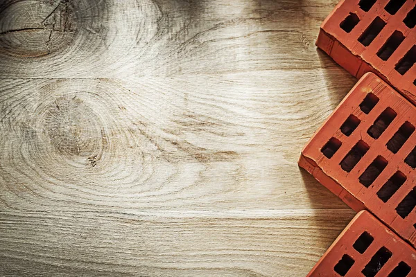 Ladrillos rojos sobre tablero de madera concepto de albañilería —  Fotos de Stock