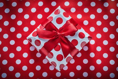 Hediye kutusu ile berabere kalan şerit üzerinde benekli kırmızı masa örtüsü celebratio