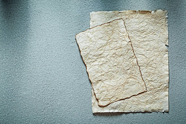 Ancient crumpled manuscripts on grey surface