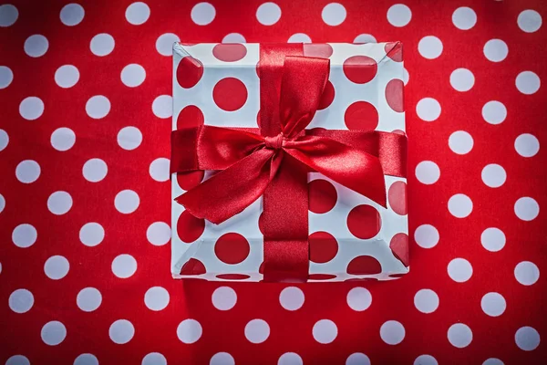 Boîte cadeau blanche avec ruban noué sur tissu rouge à pois celeb — Photo