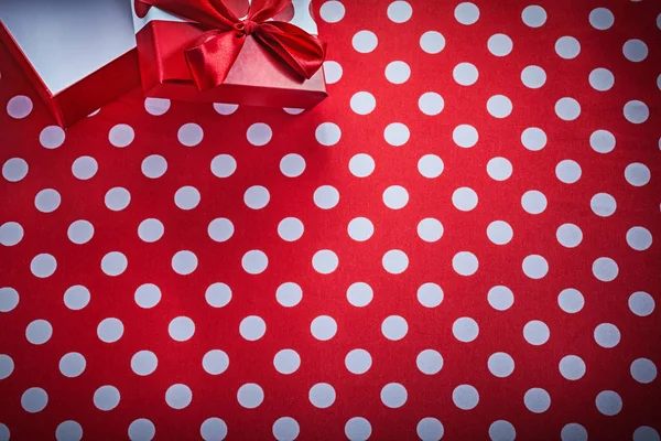 Boîte cadeau ouverte avec noeud sur les célébrations en tissu rouge à pois co — Photo
