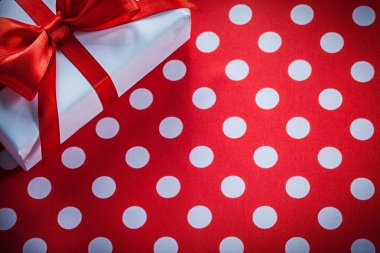 Beyaz hediye kutusu ile berabere kalan şerit üzerinde benekli kırmızı kumaş celebrat