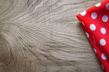 Kırmızı beyaz pamuklu katlanmış benekli masa örtüsü ahşap tahta polis üzerinde