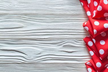 Ahşap tahta kopya alanı üzerinde kırmızı katlanmış benekli masa örtüsü