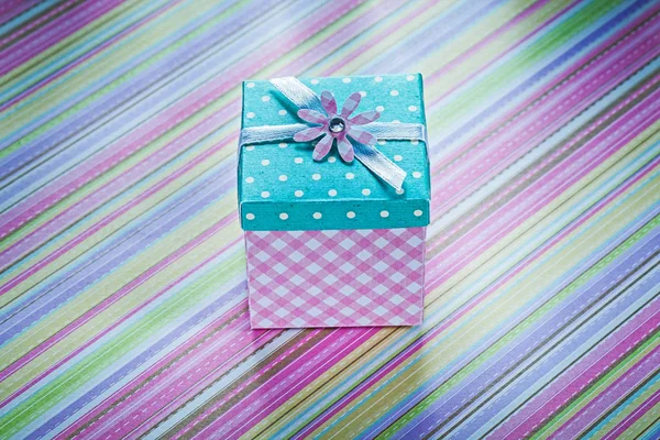 Caja de regalo en la superficie de tela rayada directamente encima de las vacaciones co — Foto de Stock