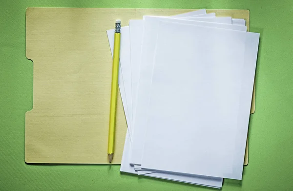 Cartella ufficio fogli di carta matita su sfondo verde — Foto Stock