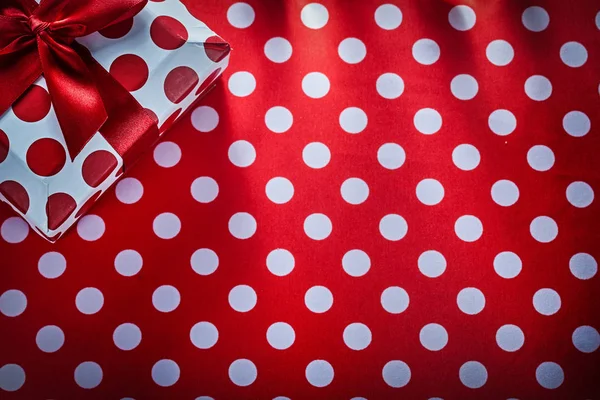 Boîte cadeau avec ruban noué sur nappe rouge à pois vacances — Photo
