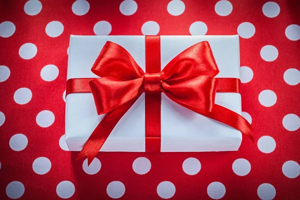 Present box on polka-dot red fabric celebrations concept — Stock Photo, Image