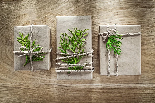 Caixas de presente artesanais embrulhadas em papel de loja com ramo verde h — Fotografia de Stock