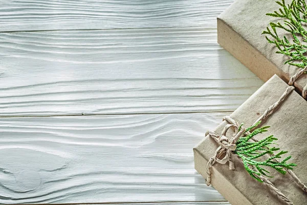 Set de coffrets cadeaux faits à la main avec des branches vertes sur panneau en bois — Photo