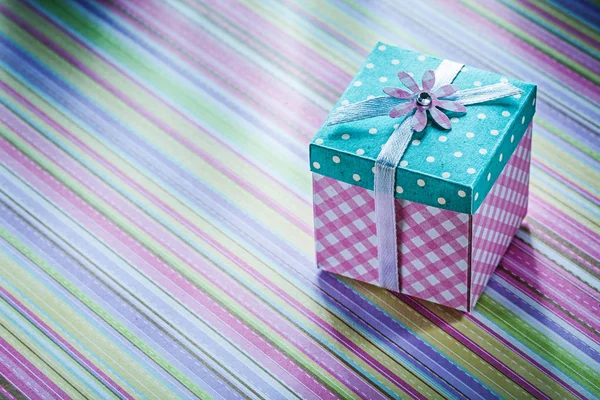 Caja de regalo envuelta en celebraciones de fondo de tela a rayas con — Foto de Stock