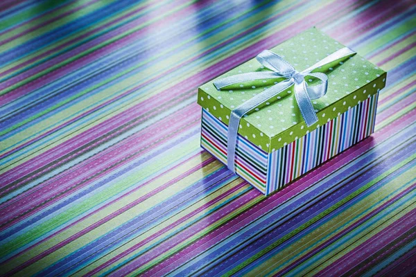 Pappschachtel mit Geschenk auf gestreiftem Stoff — Stockfoto