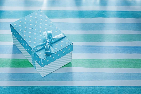 Confezione regalo su tovaglia a righe blu concetto vacanze — Foto Stock