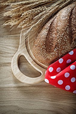 Doğrama kurulu çavdar kulakları kırmızı masa örtüsü üzerinde ahşap backgrou ekmek
