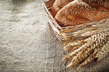 Hasır sepet ekmeği buğday kulak arka plan çuval bezi üzerinde