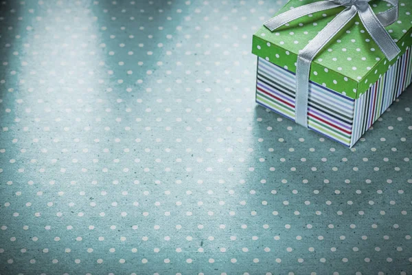 Packed gift on blue polka-dot tablecloth holidays concept