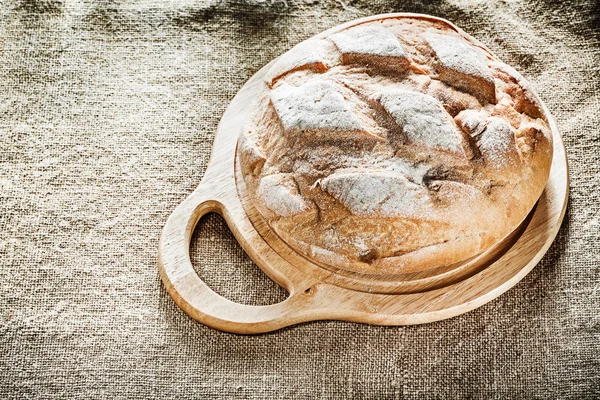 Chopping board bread on burlap background — Stock Photo, Image