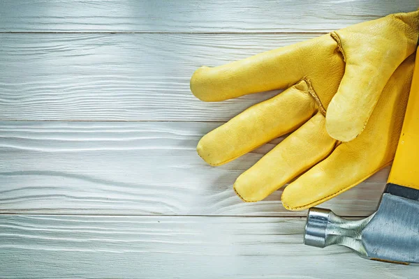 Leather protective glove claw hammer on wooden board — Stock Photo, Image