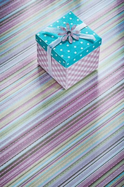 Caixa de presente na superfície do tecido listrado diretamente acima celebração — Fotografia de Stock