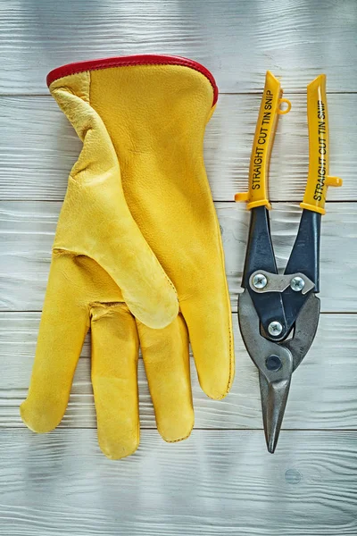 Leather safety gloves tin snip on wooden board — Stock Photo, Image