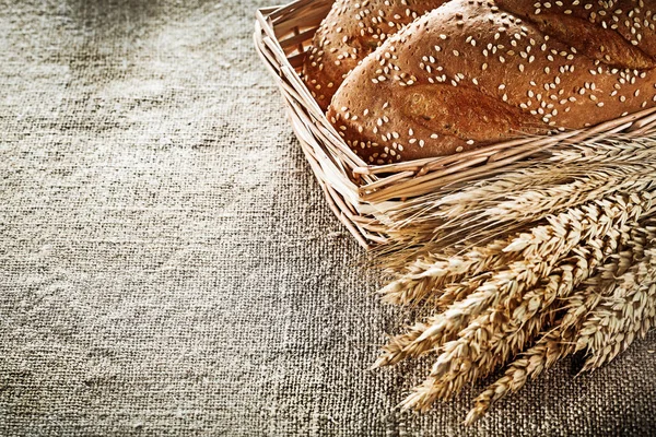 Cesta de mimbre espigas de trigo palo de pan en el saqueo de fondo —  Fotos de Stock