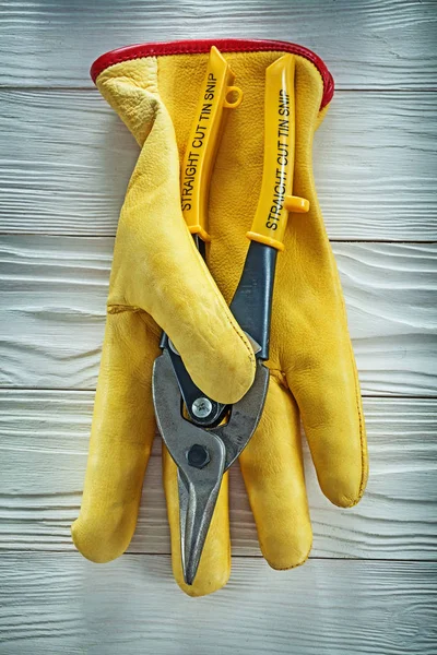 Leather safety gloves cutting pliers on wooden board