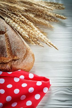 Beyaz tahta üzerinde kahverengi ekmek buğday kulakları kırmızı benekli masa örtüsü