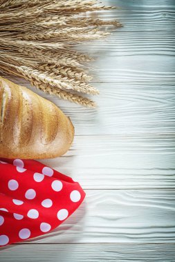 Beyaz tahta üzerinde ekmek sopa buğday kulakları kırmızı masa örtüsü