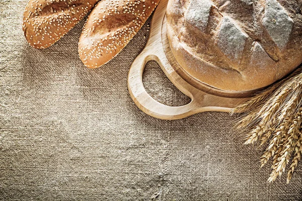 Schnitzbrett Brot Baguette Weizenähren auf Säckelgrund — Stockfoto
