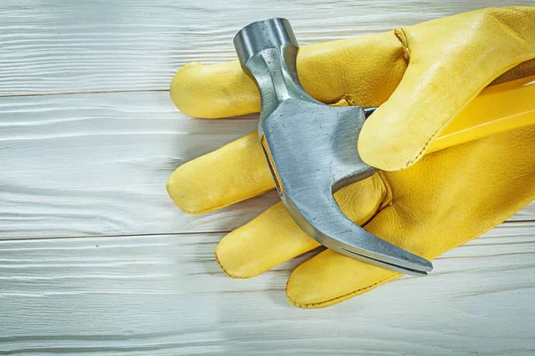 Leather safety glove claw hammer on wooden board — Stock Photo, Image