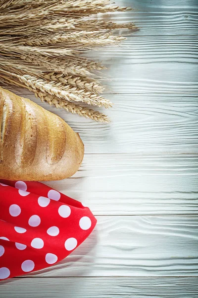 Beyaz tahta üzerinde ekmek sopa buğday kulakları kırmızı masa örtüsü