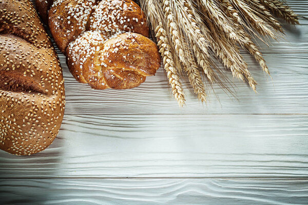 Loaf of bread wheat ears on white board