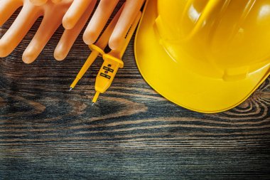 Sabit şapka eldiven elektrik tester ahşap tahta üzerinde yalıtım