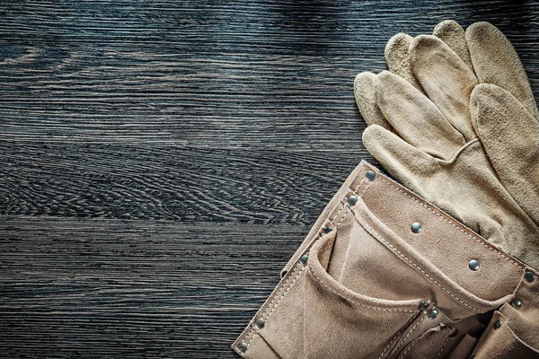 Leather building belt pair of protective gloves on black board