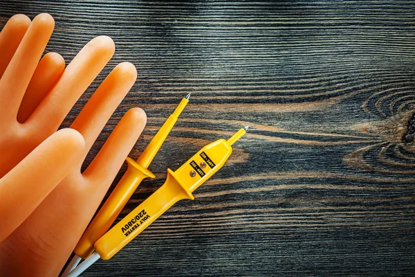 Pair of insulating gloves electric tester on wooden board — Stock Photo, Image