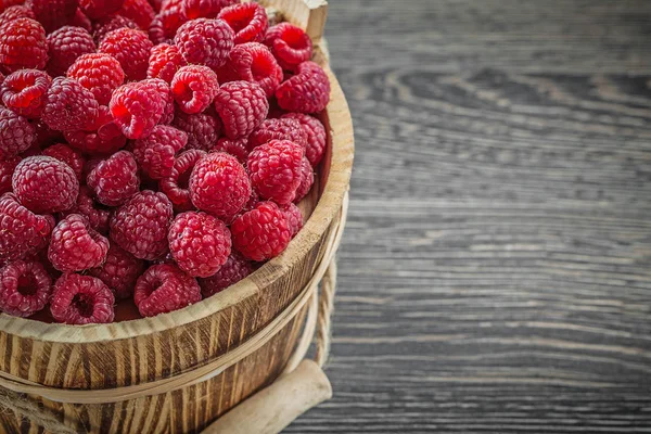 Raspberries in bucket on vintage wooden board horizontal image — Stock Photo, Image