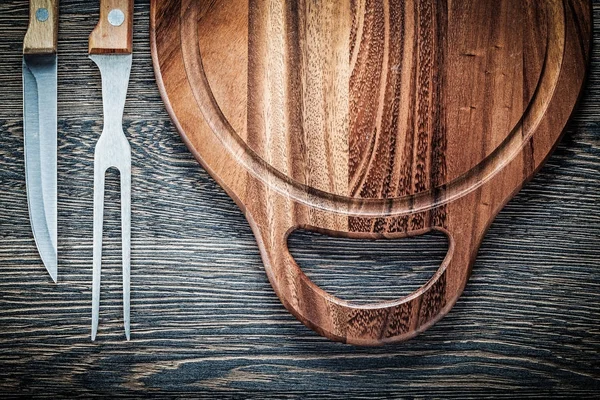 Meat fork knife carving board on vintage wooden background — Stock Photo, Image